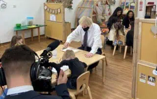 Colorful early childhood classroom at Monkey Puzzle Day Nurseries with children engaging in activities, supervised by an adult, showcasing a vibrant learning environment for young kids.