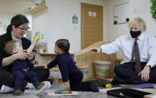 Children engaging in playful learning activities at Monkey Puzzle Day Nurseries with staff and visitors, fostering development and social interaction in a nurturing environment.
