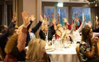 Group participation at the Network Conference People at a conference raising their hands during a session at Monkey Puzzle Day Nurseries event.