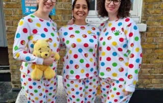 Brightly dressed staff members in colorful polka dot outfits celebrating a fun event at Monkey Puzzle Day Nurseries.