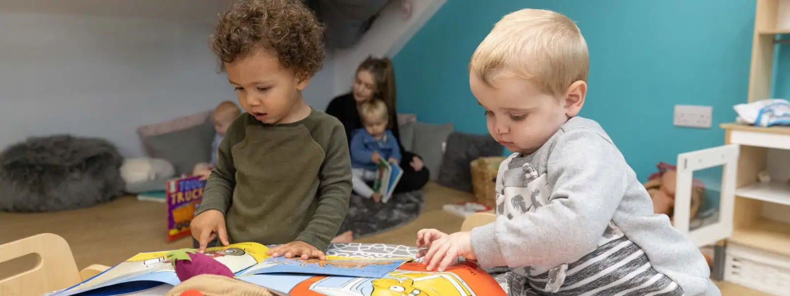Children engaging with picture books at Monkey Puzzle Day Nurseries, providing a nurturing environment for early learning and development.