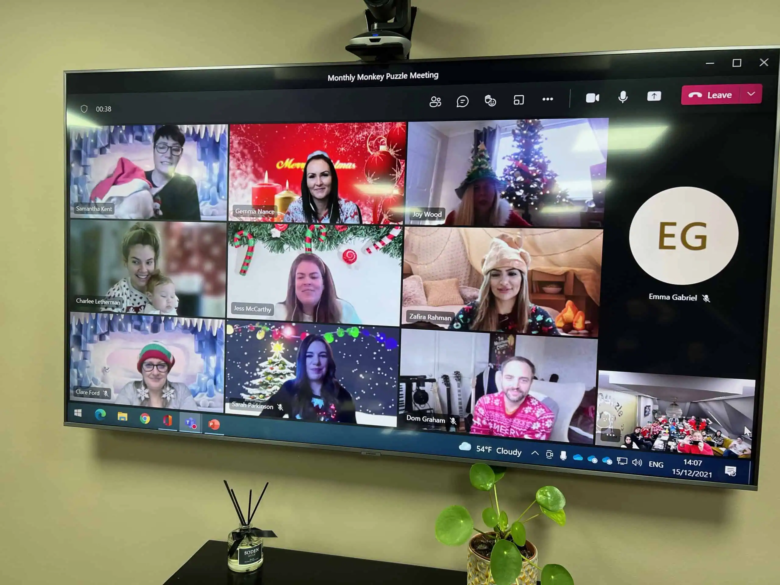 Bright and cheerful virtual Christmas meeting of Monkey Puzzle Day Nurseries staff with holiday decorations, festive costumes, and holiday cheer.