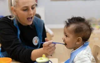 Feeding a young child in a nursery setting, showcasing nurturing care and early childhood development at Monkey Puzzle Day Nurseries.