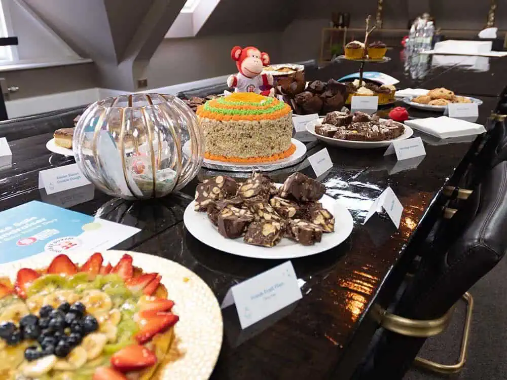 Cakes at the Monkey Puzzle Bake Sale Colorful birthday cake and assorted desserts displayed on a dining table at Monkey Puzzle Day Nurseries. Perfect for celebrating children’s milestones in a safe and engaging environment.