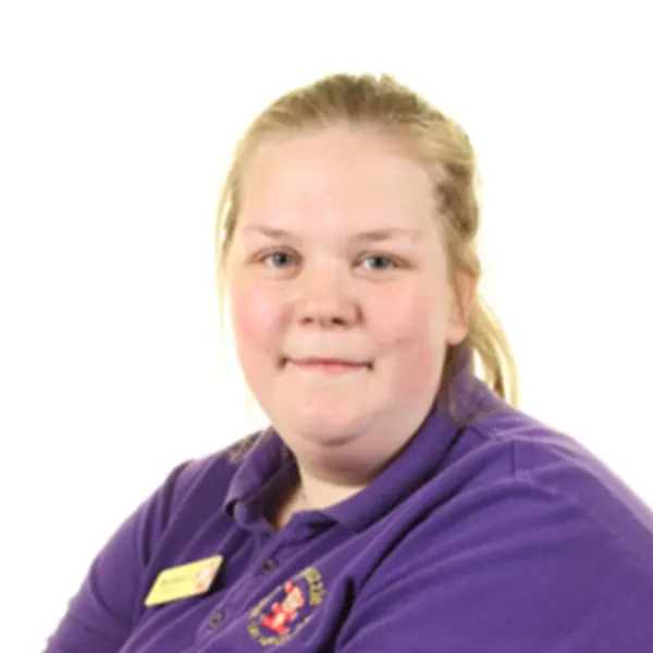 Girl smiling in purple uniform at Monkey Puzzle Day Nurseries.