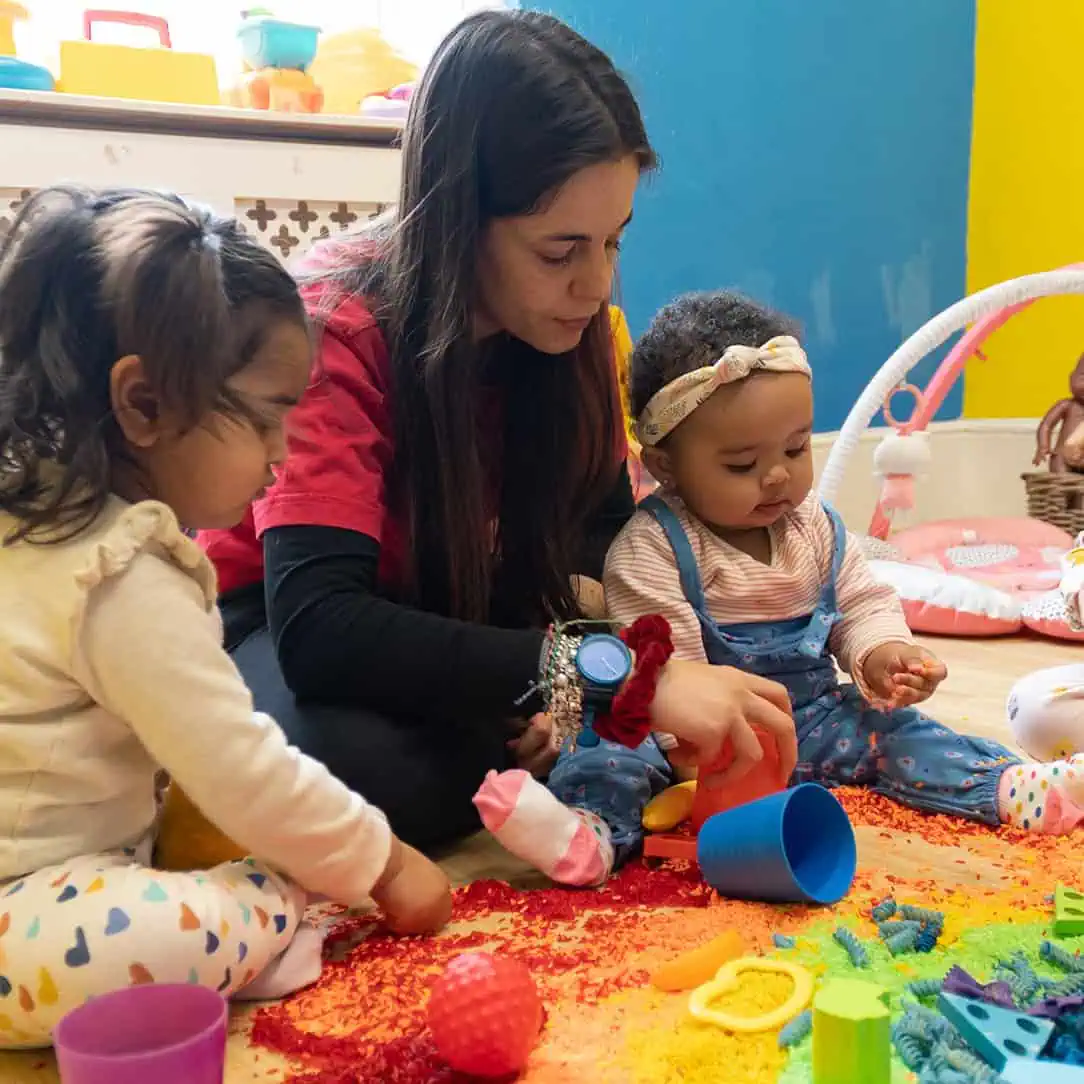 Colorful toddler playroom at Monkey Puzzle Day Nurseries with children engaging in sensory activities and educational toys.