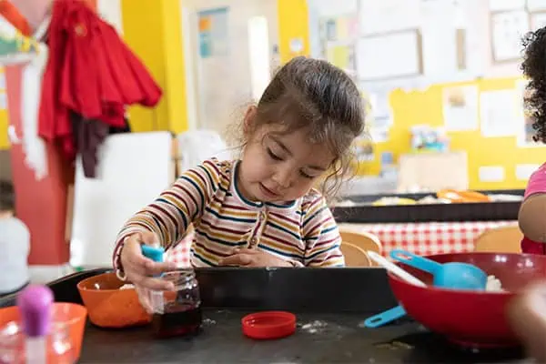Colorful preschool classroom with children engaging in creative activities at Monkey Puzzle Day Nurseries.