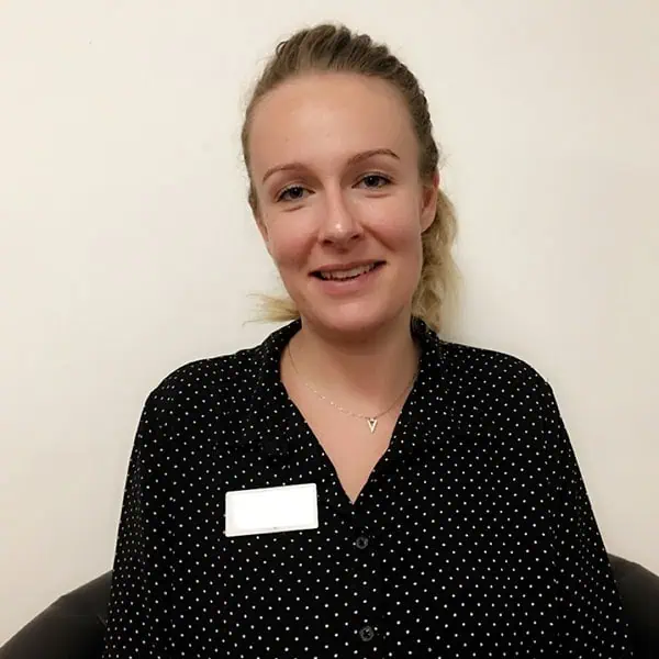 Friendly nursery staff member at Monkey Puzzle Day Nurseries, smiling and welcoming children in a caring childcare environment.