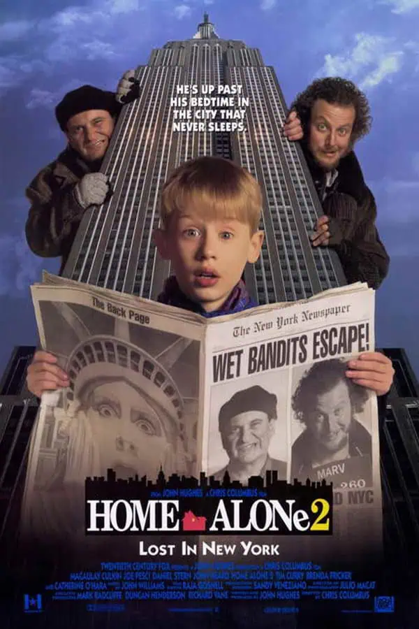 Movie poster of Home Alone 2: Lost In New York, featuring a young boy holding a newspaper with images of the Statue of Liberty, surrounded by two men, with the Empire State Building in the background, capturing the adventurous spirit of New York City.