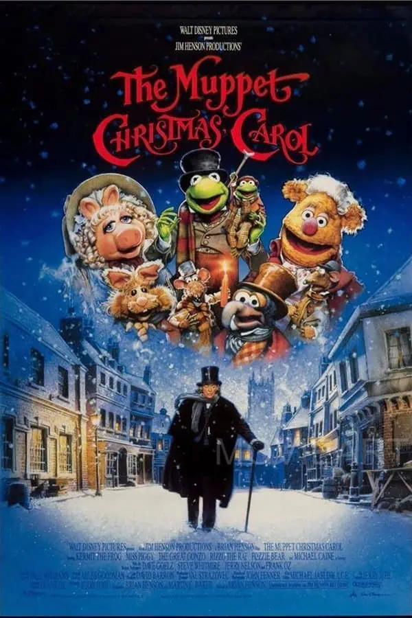 Kermit the Frog and the Muppets characters from "The Muppet Christmas Carol" in a festive snow-covered street scene, promoting holiday cheer and family-friendly entertainment.