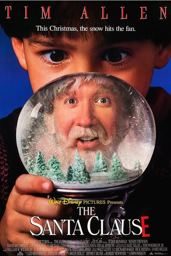 Cute young boy holding a snow globe featuring Santa Claus, perfect for Christmas-themed nursery decor and activities.