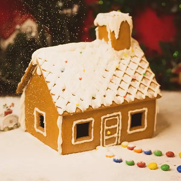 Decorative gingerbread house for kids' holiday celebration, featuring colorful candy decorations and icing roof, creating a festive and inviting atmosphere for young children at Monkey Puzzle Day Nurseries.