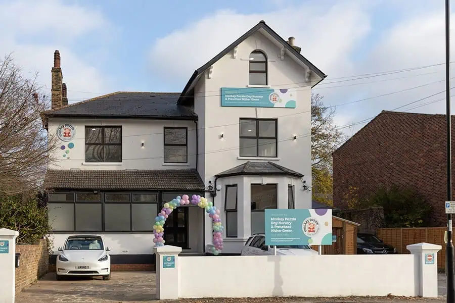Monkey Puzzle Hither Green Monkey Puzzle Day Nursery building exterior with colorful balloon arch for grand opening, offering preschool childcare services in Higher Green.