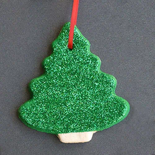 Green glitter Christmas tree-shaped cookie decoration at Monkey Puzzle Day Nurseries, perfect for festive nursery activities and holiday celebrations in early childhood education.