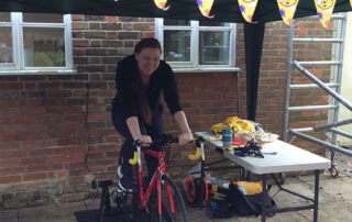 Staff supporting Andy, taking turns on the bike