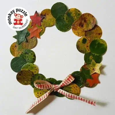 Colorful natural leaf and star-shaped craft wreath for children at Monkey Puzzle Day Nurseries, emphasizing early childhood creativity and play-based learning.