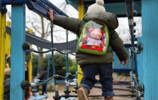 Colorful outdoor playground at Monkey Puzzle Day Nurseries with young children engaging in climbing activities, promoting fun, physical activity, and early childhood development.