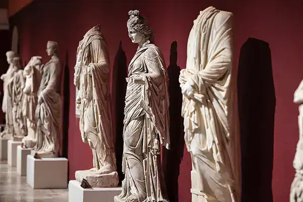 Ancient Greek marble sculptures displayed in a museum, showcasing classical artistry and cultural heritage.