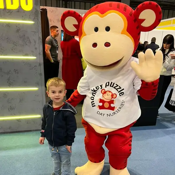 Marvin the Monkey, the mascot of Monkey Puzzle Day Nurseries, meeting children at an exhibition