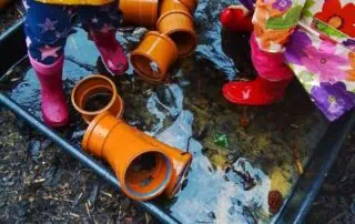 Watering activity for young children outdoor play at Monkey Puzzle Day Nurseries.