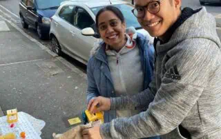 Bright smiling people at outdoor charity event in London, showcasing joyful community engagement outside Monkey Puzzle Day Nurseries.