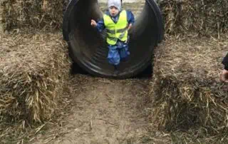 Children playing outdoors at Monkey Puzzle Day Nurseries, enjoying nature and physical activities in a safe, engaging environment.