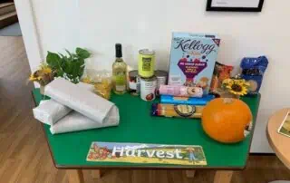 Fresh produce and harvest-themed decorations on a bright green table at Monkey Puzzle Day Nurseries, emphasizing healthy eating and seasonal awareness for young children.