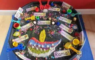 Colorful Diwali-themed sensory play tray with rice, glitter, and small toys celebrating the Indian festival of lights at Monkey Puzzle Day Nurseries.