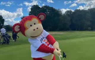 Colorful monkey mascot in golf attire on the green at Monkey Puzzle Day Nurseries, creating a fun and engaging outdoor activity environment for young children.