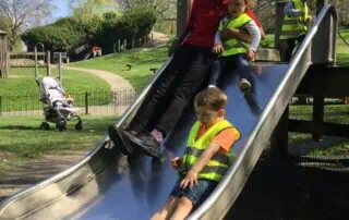 Kids playing on outdoor slide at Monkey Puzzle Day Nurseries, early childhood education, outdoor play, preschool activities, safe learning environment.