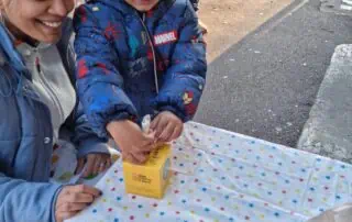 Brightly colored children's party table with Star-patterned tablecloth, showcasing joyful kids celebrating outdoors at Monkey Puzzle Day Nurseries.