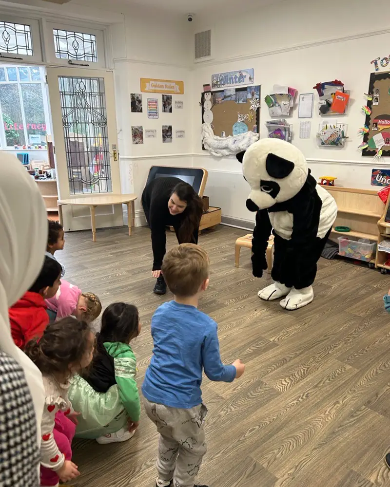 Pepper Panda dancing with nursery children during a visit to a Monkey Puzzle nursery and preschool