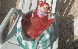 image00018 Soft toy monkey on a seaside lounge chair with a striped bag, outdoor setting at Monkey Puzzle Day Nurseries, summer play area, children’s toys, learning and play environment.