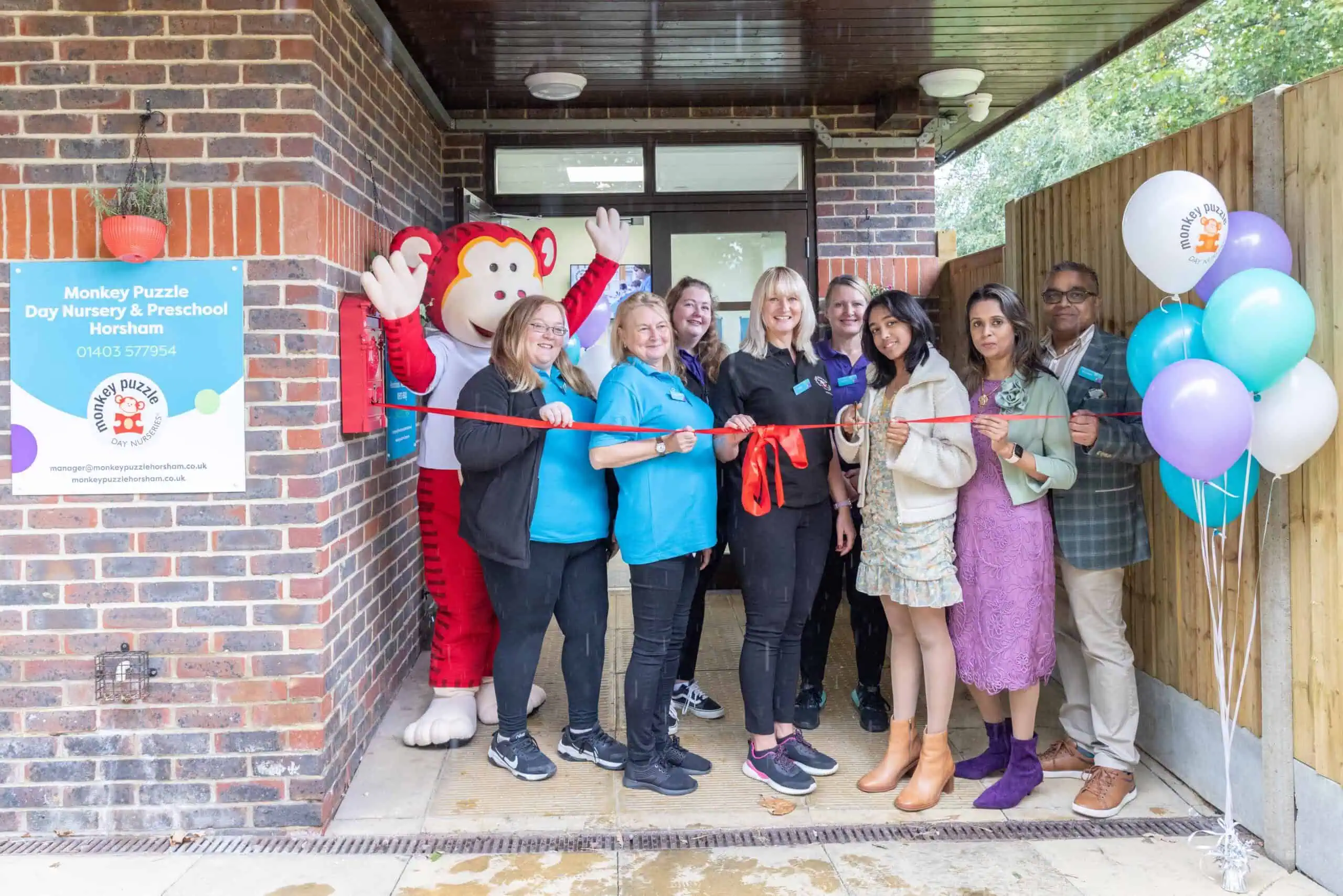 Bright group of staff and community members at the grand opening of Monkey Puzzle Day Nurseries in Horsham, celebrating childcare excellence and early childhood education.