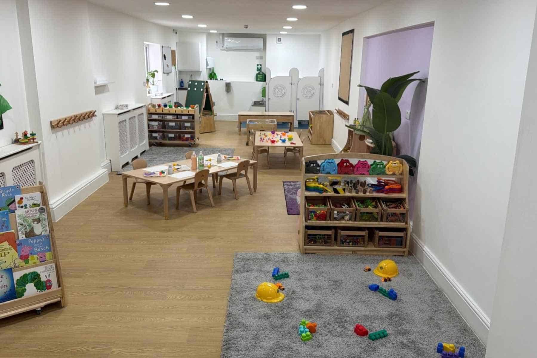 Bright and welcoming indoor play area at Monkey Puzzle Day Nurseries, featuring children's tables, educational toys, art supplies, and play zones designed for early childhood development and learning.