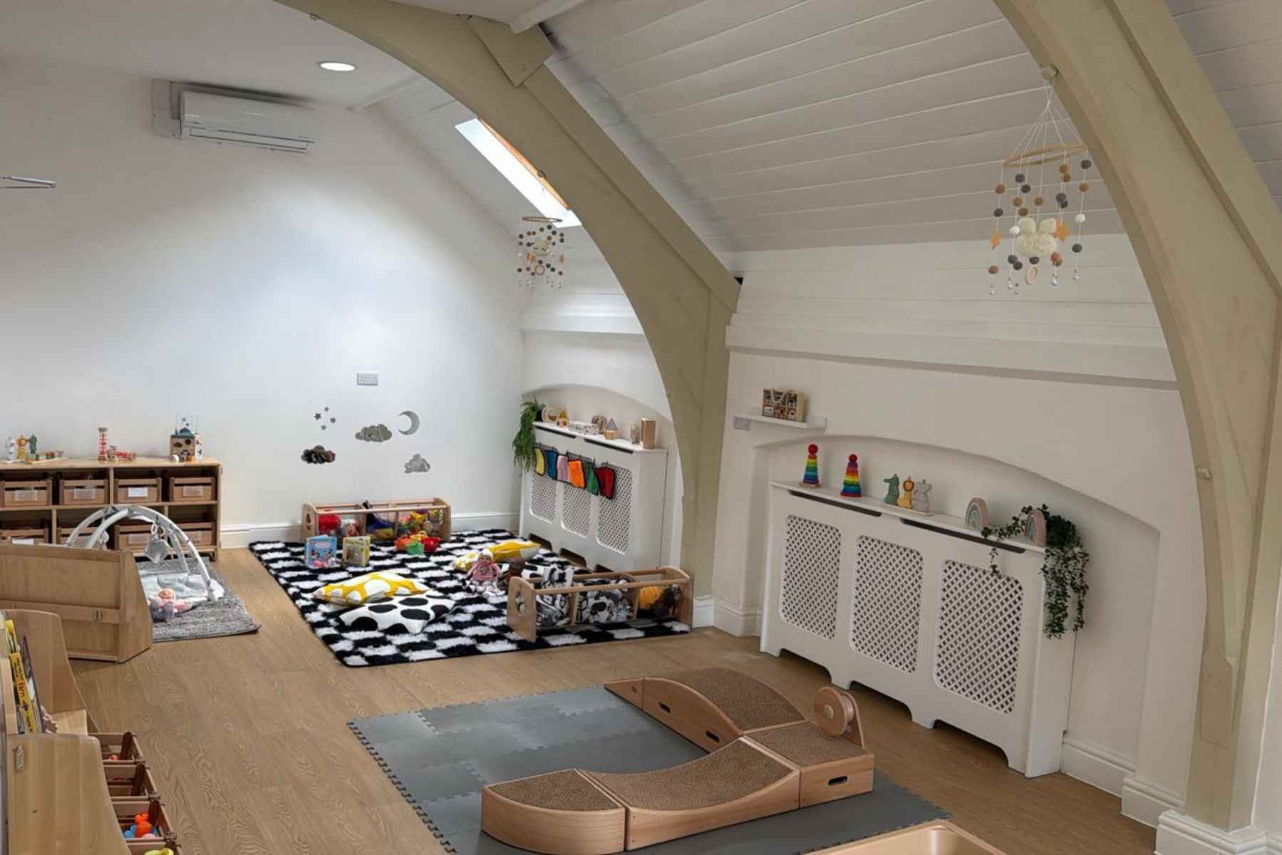 Bright and welcoming indoor play area at Monkey Puzzle Day Nurseries, featuring age-appropriate toys, cozy reading nooks, and safe, stimulating environment for early childhood development and learning.