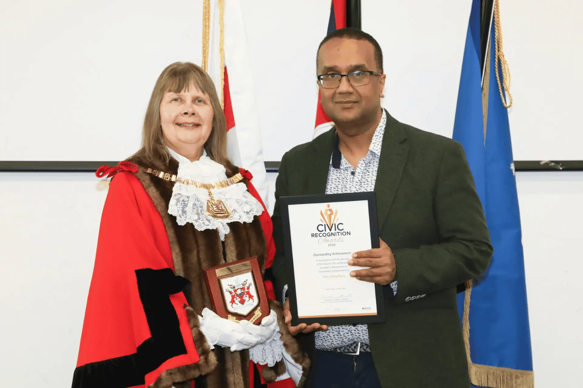 Monkey Puzzle Day Nurseries Award Ceremony A woman in ceremonial robes and a man holding a civic recognition certificate at Monkey Puzzle Day Nurseries event.
